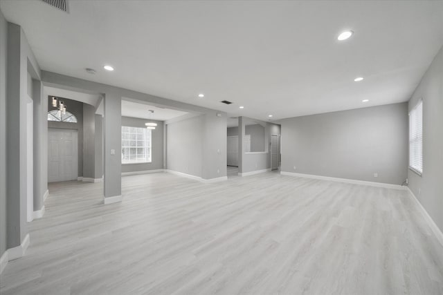 basement featuring a notable chandelier and light hardwood / wood-style flooring