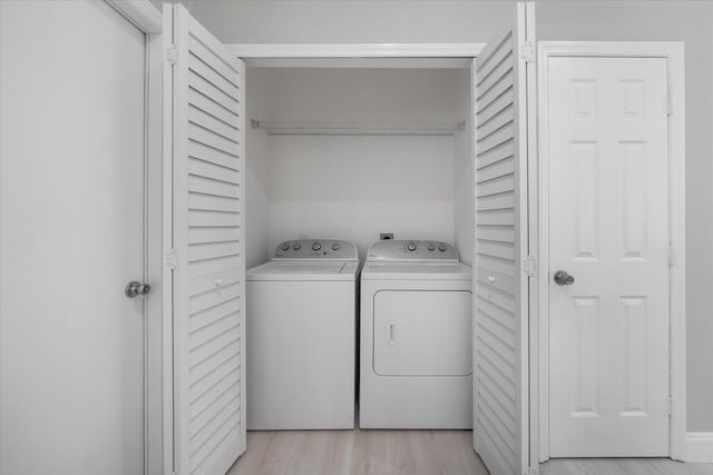 washroom featuring independent washer and dryer and light hardwood / wood-style flooring