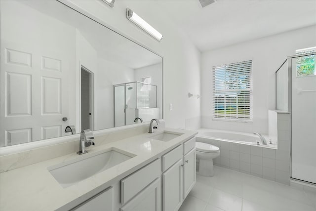 full bathroom featuring double sink, tile flooring, shower with separate bathtub, vanity with extensive cabinet space, and toilet