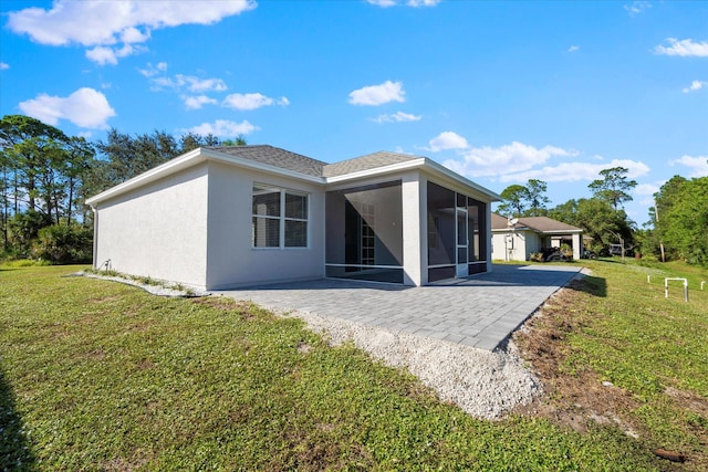 back of house featuring a yard, a sunroom, and a patio area