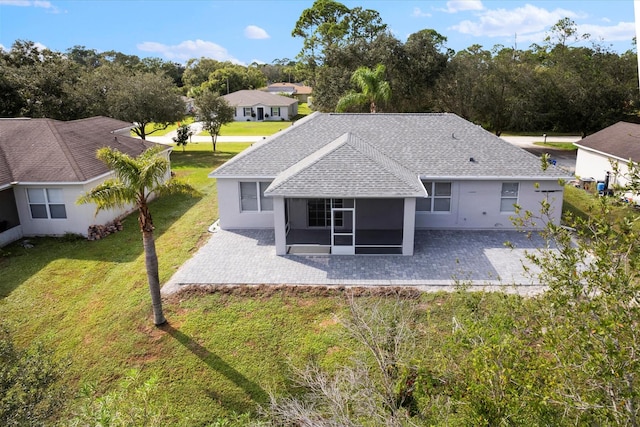 rear view of property featuring a lawn and a patio