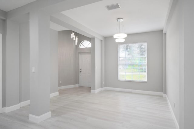 interior space featuring an inviting chandelier and light wood-type flooring