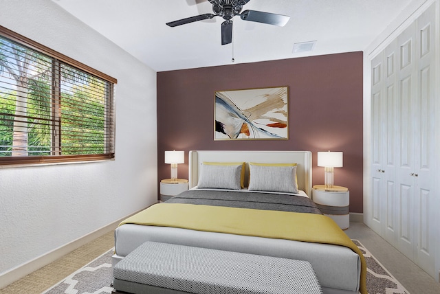 carpeted bedroom featuring ceiling fan, a closet, and multiple windows