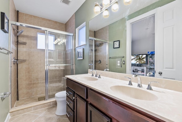 bathroom with toilet, dual bowl vanity, tile flooring, and walk in shower