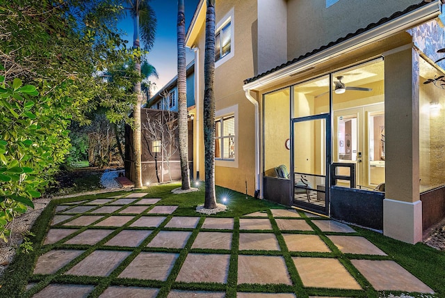 patio terrace at dusk featuring french doors and ceiling fan