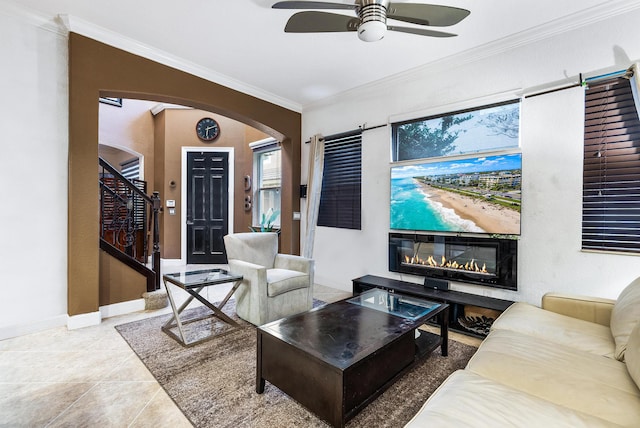 tiled living room with ornamental molding and ceiling fan