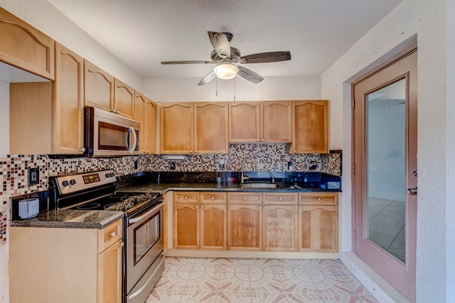 kitchen with backsplash, light tile floors, stainless steel appliances, and ceiling fan