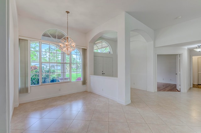 spare room featuring plenty of natural light and light tile flooring