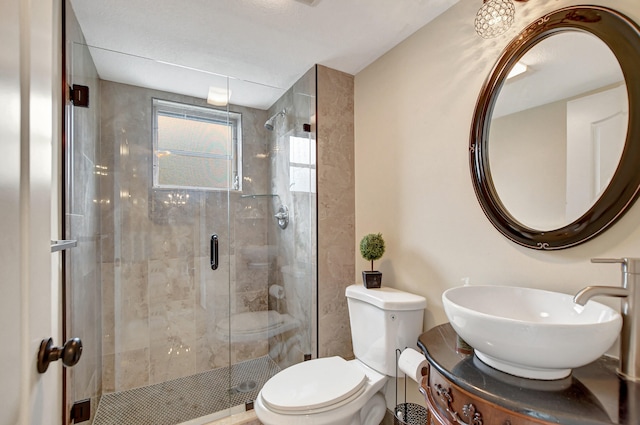 bathroom with toilet, vanity, and a shower with door