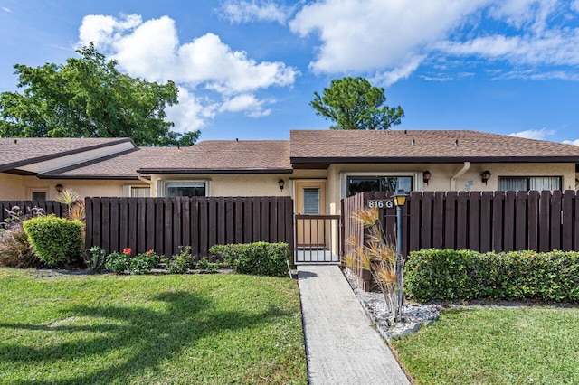 single story home featuring a front lawn