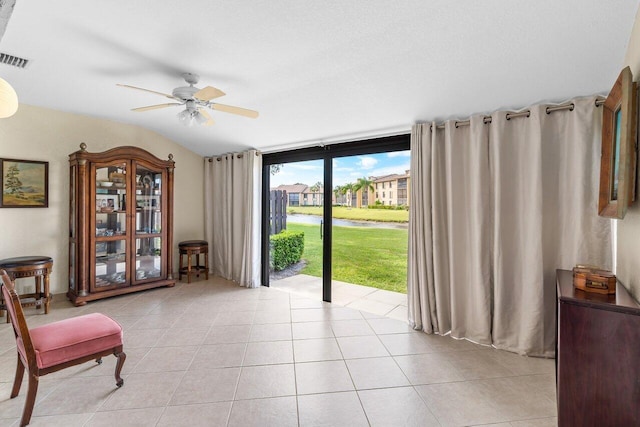 living area featuring light tile flooring and ceiling fan