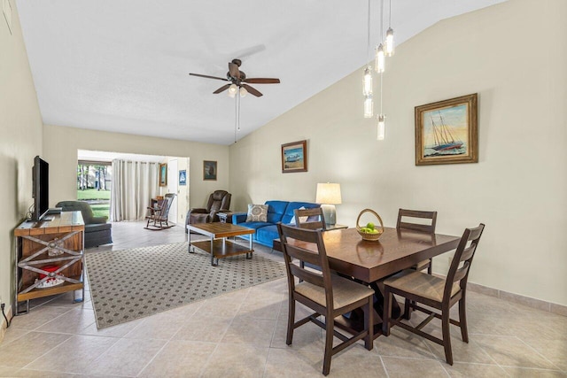 dining area with ceiling fan, light tile floors, and vaulted ceiling