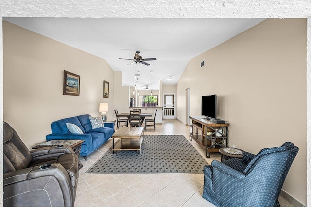 tiled living room featuring ceiling fan and vaulted ceiling