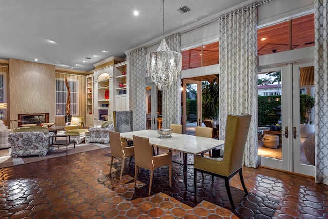 dining area featuring dark tile floors, french doors, and an inviting chandelier