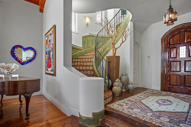 entrance foyer with dark hardwood / wood-style floors and an inviting chandelier