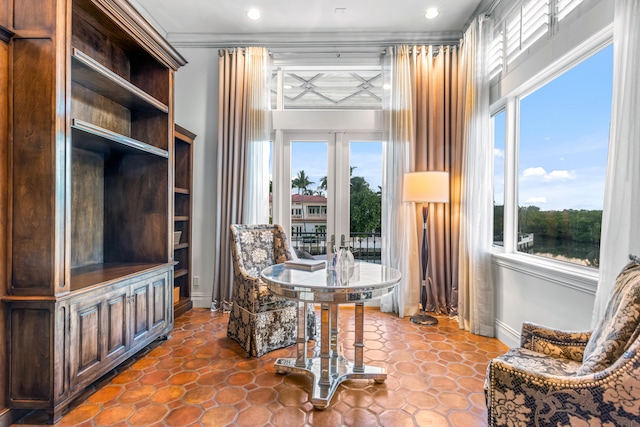 living area with plenty of natural light, tile flooring, and french doors