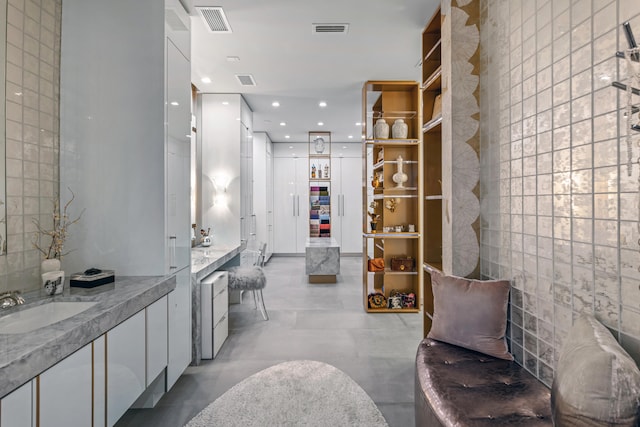 walk in closet featuring light tile floors and sink