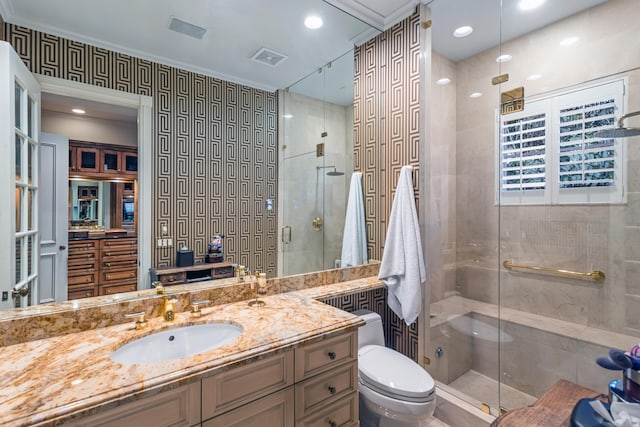 bathroom with ornamental molding, vanity, toilet, and walk in shower