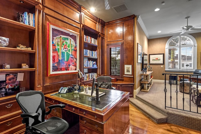 home office featuring built in features, ornamental molding, ceiling fan, and light hardwood / wood-style flooring