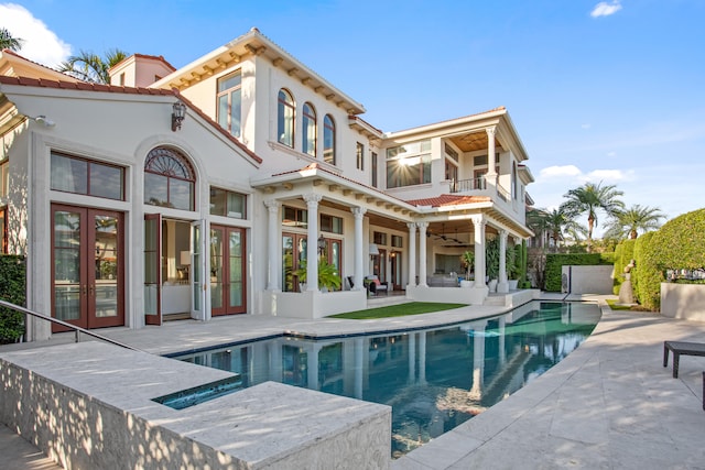 back of property with a balcony, a patio, and ceiling fan