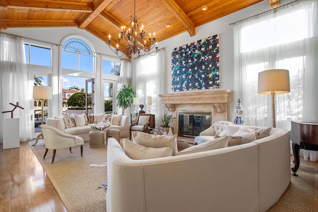 living room with wooden ceiling, a healthy amount of sunlight, and a notable chandelier