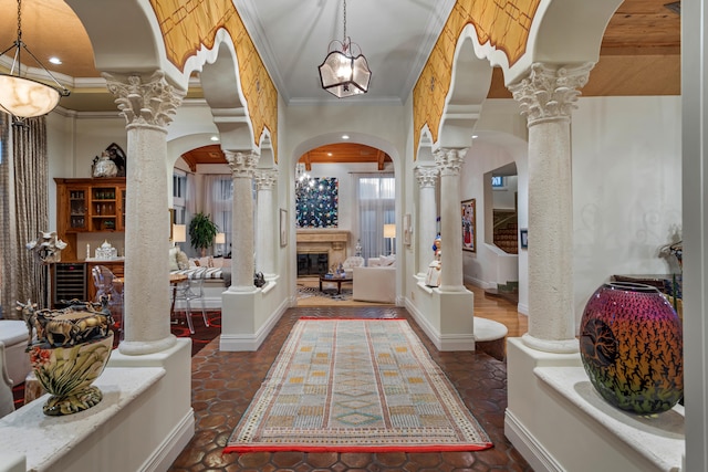 entryway with crown molding and ornate columns