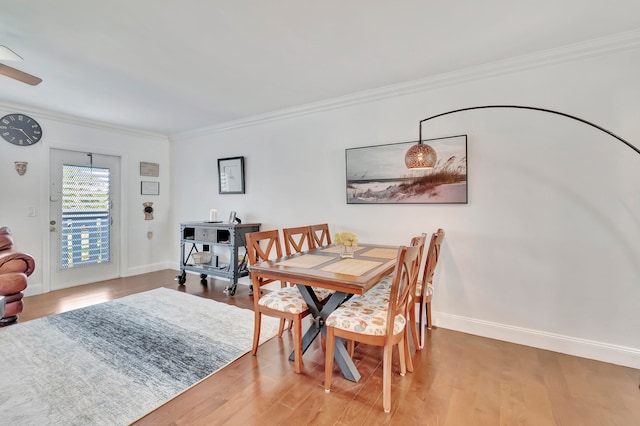 dining room with hardwood / wood-style floors, ceiling fan, and ornamental molding