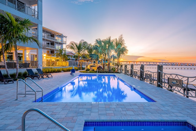 pool at dusk with a patio