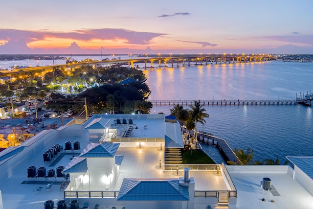 aerial view at dusk featuring a water view