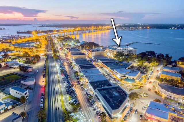 aerial view at dusk featuring a water view