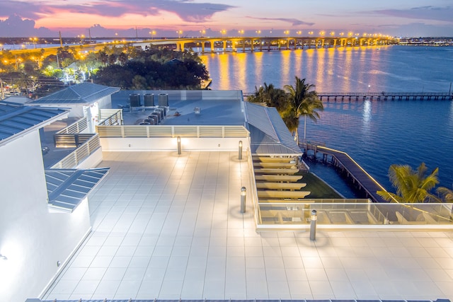 aerial view at dusk featuring a water view