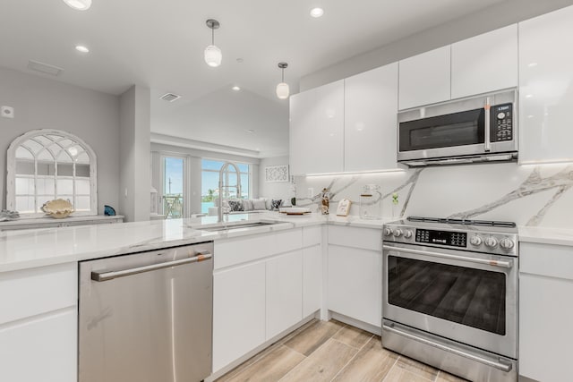 kitchen featuring white cabinetry, sink, appliances with stainless steel finishes, and light wood-type flooring