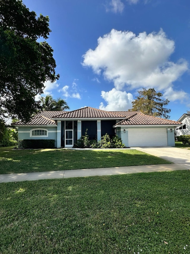 view of front of property with a garage and a front lawn