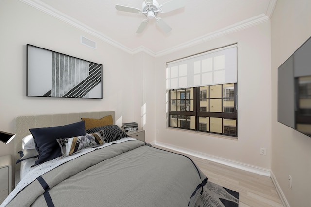 bedroom featuring light hardwood / wood-style floors, ceiling fan, and crown molding