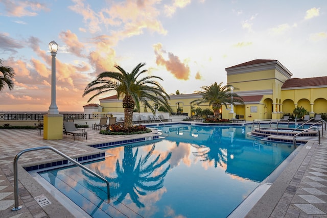 pool at dusk featuring a patio area