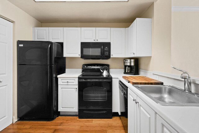 kitchen with white cabinets, light hardwood / wood-style floors, black appliances, and sink