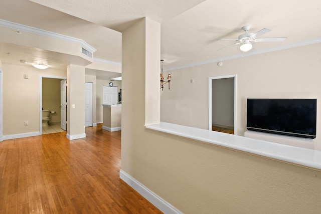 hall with ornamental molding, light hardwood / wood-style floors, a notable chandelier, and a textured ceiling