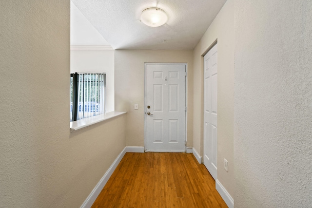 doorway featuring a textured ceiling and light hardwood / wood-style flooring