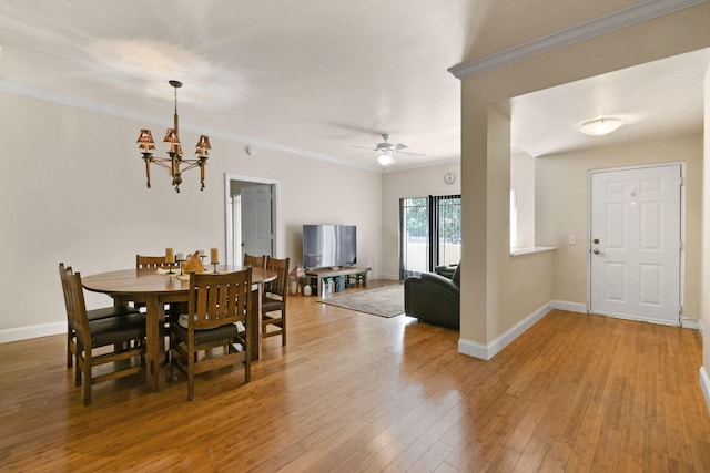 dining space featuring ornamental molding, ceiling fan with notable chandelier, and light wood-type flooring