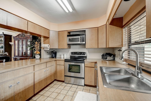 kitchen featuring appliances with stainless steel finishes, light brown cabinetry, sink, and light tile floors