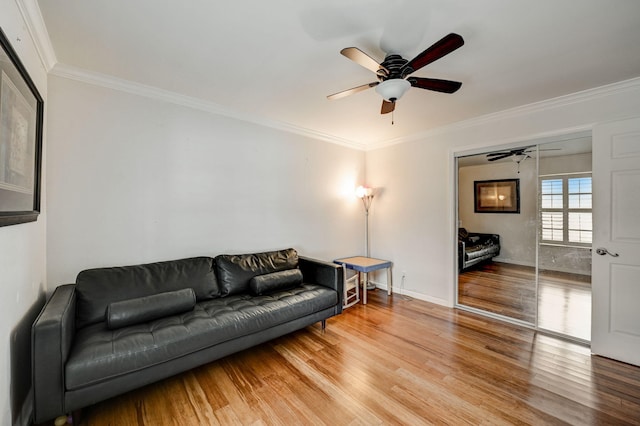 living room with ornamental molding, ceiling fan, and light hardwood / wood-style flooring