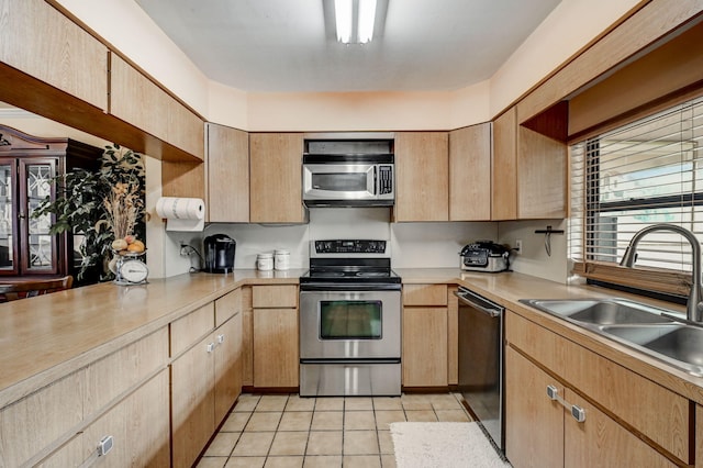 kitchen with sink, light tile floors, and stainless steel appliances