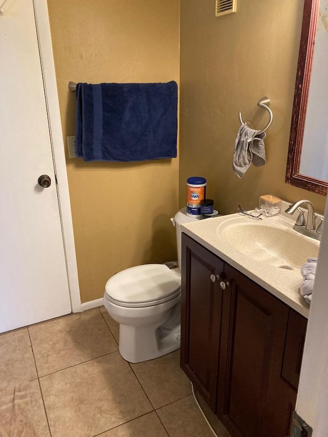 bathroom featuring toilet, tile floors, and vanity