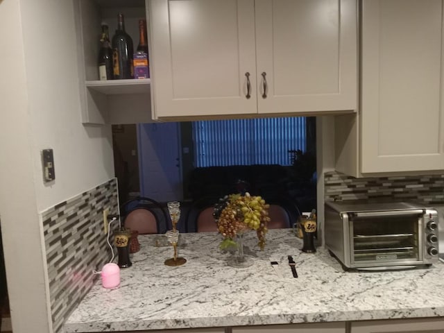 kitchen featuring backsplash and light stone counters