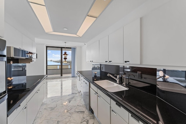 kitchen featuring dishwasher, sink, black electric stovetop, and white cabinets