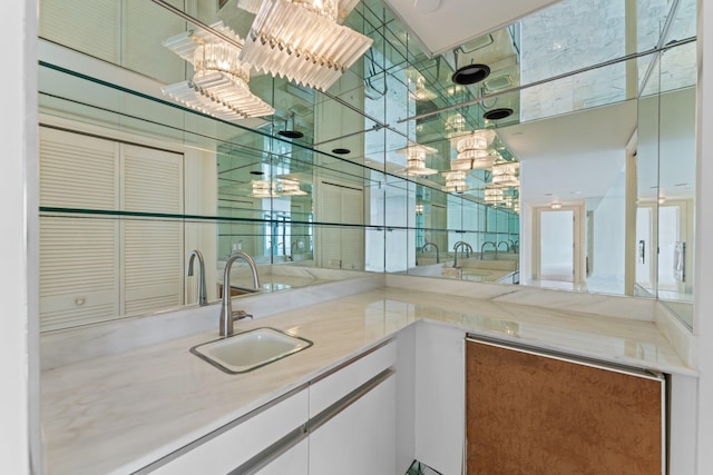 bar with white cabinetry and sink