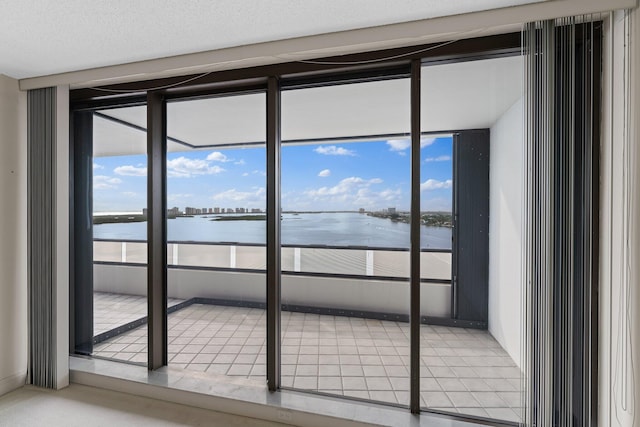 empty room featuring a water view and a textured ceiling