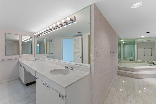 bathroom featuring vanity and tiled bath