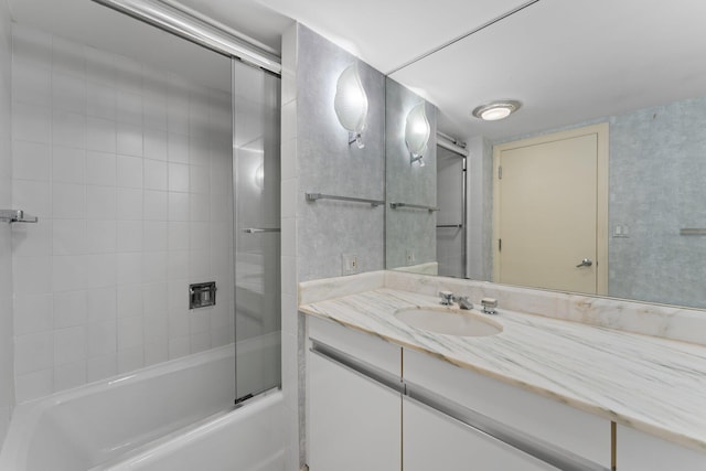 bathroom with combined bath / shower with glass door and vanity