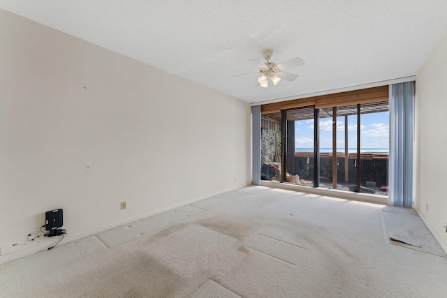 carpeted empty room with a textured ceiling and ceiling fan